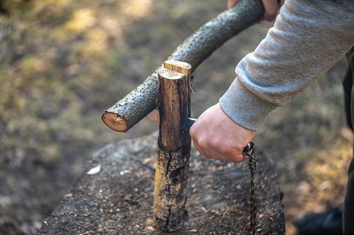 Cutting firewood with a bushcraft knife and a log during survival courses in crozon brittany outdoor